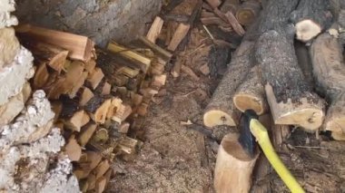 Axe for cutting logs near stacked woods. Close-up top view.