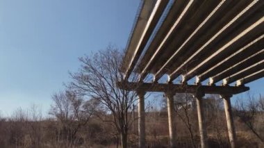 Şehir karayolu köprüsünün bitmemiş kısmının havadan görüntüsü. Terk edilmiş viyadük. İHA videosu, üst görüntü. Yol çalışması otoyolu rampası. Döner kavşak inşası.