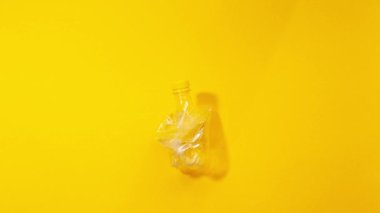 Hareket animasyonu konseptini durdur. Sarı zemin üzerinde plastik şişe yakın plan.