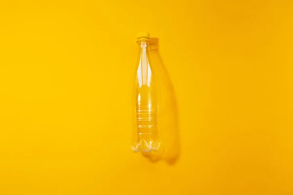 Вид Сверху Пустую Прозрачную Пластиковую Бутылку Желтом Фоне — стоковое фото