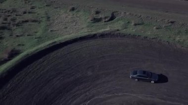 Kirli kırsal yollarda insansız hava aracıyla çekim yapan gri arabanın hava manzarası tek başına off-road yapıyor..