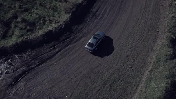 无人驾驶飞机拍摄的在肮脏的乡间道路上独自驾驶灰色汽车的空中俯瞰图 — 图库视频影像