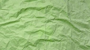 Hareket fotoğrafçılığı animasyon konseptini durdur. Kırışmış yeşil renkli kağıtların yakın çekimi. Kopyalama alanı olan desenli soyut arkaplan.