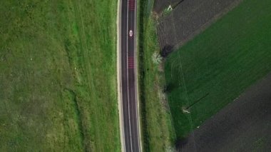 Yeşil alan ve tarım arazisi arasındaki ulusal yolun asfaltlanmasına dair havadan bir bakış açısı. İnsansız hava aracı görüntüleri.
