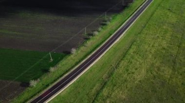 Yeşil alan ve tarım arazisi arasındaki ulusal yolun asfaltlanmasına dair havadan bir bakış açısı. İnsansız hava aracı görüntüleri.