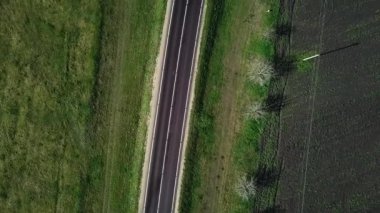 Yeşil alan ve tarım arazisi arasındaki ulusal yolun asfaltlanmasına dair havadan bir bakış açısı. İnsansız hava aracı görüntüleri.