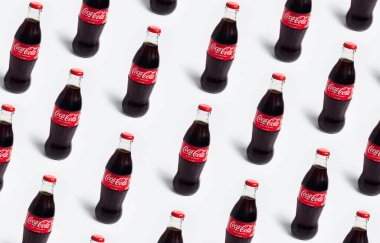 Beyaz arka planda izole edilmiş Coca Cola şişelerinin deseni. Chisinau, Moldova - 28 Nisan 2023.