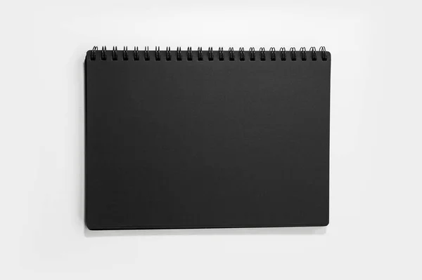 白い背景に独立したモックアップ付き黒の閉じたノートブックのクローズアップ — ストック写真