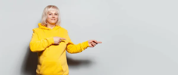 스웨터를 공간을 손가락으로 가리키는 여성의 스튜디오 파노라마같은 — 스톡 사진