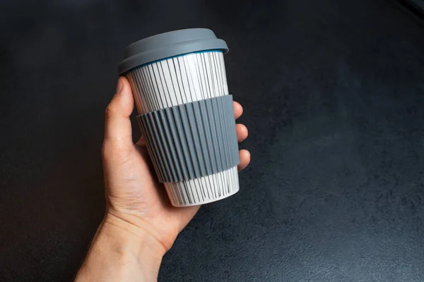 黒を基調としたコーヒー用のセラミックカップを持つ男性の手のクローズアップ — ストック写真