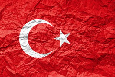 Buruşmuş kağıt üzerinde bir Türk bayrağı. Desenli arkaplan.