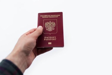 Erkek elinin yakın plan fotoğrafı, Rus pasaportu, beyaz arka planda izole edilmiş..