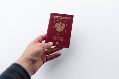 Beyaz arka planda izole edilmiş Rus pasaportu taşıyan erkek eli yakın plan..