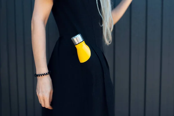 Κοντινό Πλάνο Της Νεαρής Κοπέλας Μαύρο Φόρεμα Κίτρινο Θερμό Μπουκάλι — Φωτογραφία Αρχείου