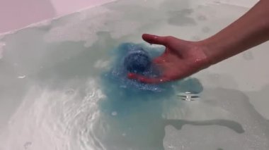 Küvet bombasının içine kadın eli düşüşü yakın plan..