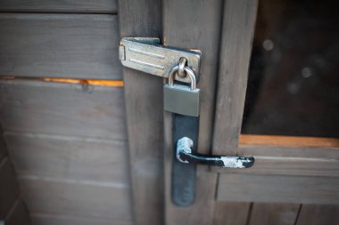 Dış asma kilidi yakın çekim ve eski ahşap kapı tutacağı.