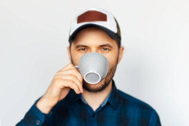 Gri fincandan kahve içen genç adamın portresi..