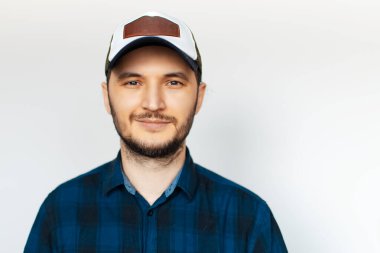 Beyaz arka planda mavi gömlekli genç bir adamın stüdyo portresi..