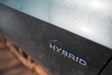 Kirli araba gövdesine Melez ikonu yakın plan. Çevre konsepti. Ekolojik Taşıma.