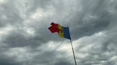 Moldova Cumhuriyeti bayrağı bulutlu gökyüzünün arka planında dalgalanıyor. 60 fps video.