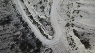 Kum tepeleri arasındaki hava manzaralı köy yolu. İnsansız hava aracı görüntüleri. Doğal desenli arkaplan.
