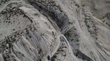 Kum tepeleri arasındaki hava manzaralı köy yolu. İnsansız hava aracı görüntüleri. Doğal desenli arkaplan.