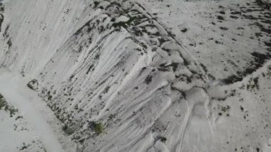 Kum tepeleri arasındaki hava manzaralı köy yolu. İnsansız hava aracı görüntüleri. Doğal desenli arkaplan.