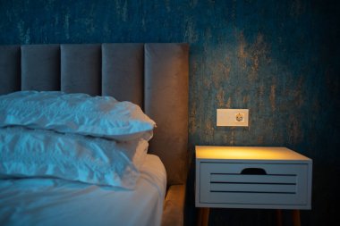 Şık komodinli rahat yatak ve dokunmatik lamba düğmeli modern soket..