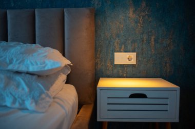 Şık komodinli rahat yatak ve dokunmatik lamba düğmeli modern soket..