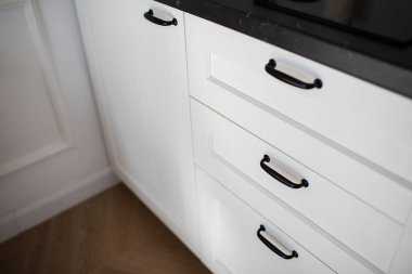 Siyah metal saplı ve meşe ağacından yapılmış beyaz mutfak cephesi..