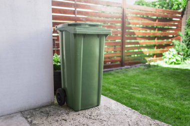 Arka bahçedeki çöpler için yeşil büyük plastik kutu..