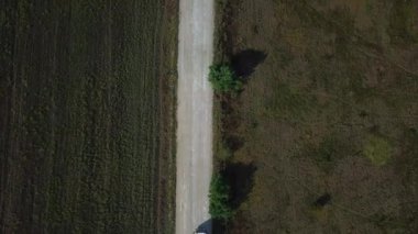Kargolu kamyonun hava görüntüsü beyaz kırsal bir yolda ilerliyor. İnsansız hava aracı görüntüleri.