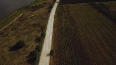 Kargolu kamyonun hava görüntüsü beyaz kırsal bir yolda ilerliyor. İnsansız hava aracı görüntüleri.