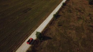 Kargolu kamyonun hava görüntüsü beyaz kırsal bir yolda ilerliyor. İnsansız hava aracı görüntüleri.