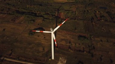 Tarımsal topraklar arasında yeşil enerji üreten rüzgar türbininin hava görüntüsü. İnsansız hava aracı görüntüleri.