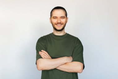 Beyaz arka planda el ele tutuşan, kendinden emin gülümseyen genç bir adamın portresi..