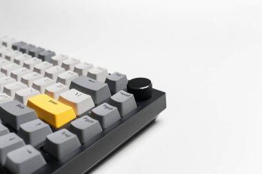 Beyaz arkaplandaki bilgisayar için mekanik klavye. Gri, siyah ve sarı renklerin anahtar başlığı.