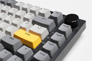 Beyaz arkaplandaki bilgisayar için mekanik klavye. Gri, siyah ve sarı renklerin anahtar başlığı.