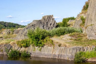 Ağaçların yetiştiği görkemli bazalt dağları. Çek Cumhuriyeti 'nin enginliğinde çubuk şeklinde altıgen taş dağlar