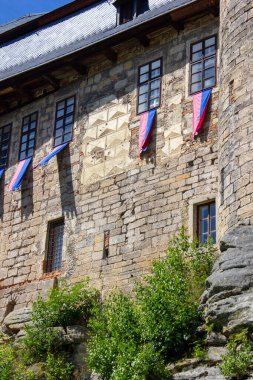 Peri masalı, ortaçağ, pencereli ve kemerli taş kale Kost. Çek Cumhuriyeti 'nde yeşil ağaçlı bir kayanın üzerine inşa edilmiş.