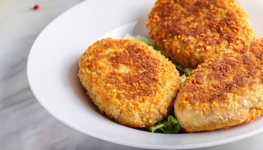 Marul yaprağında iki tavuk pirzolası, patates püresi ve domates sosu. Kiev usulü pirzola