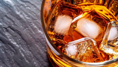 Viski kristal bardağa dökülüyor. Üst Manzara. Altın sıvı beyaz arka planda bir bardağa dökülüyor. Fotoğrafın sağ kısmına boşluk kopyala.