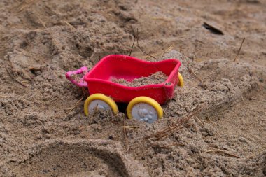 Kumdaki kırmızı oyuncak karavanı