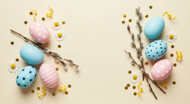 Paskalya yumurtaları ve pastel arka planda bahar dalları. Üst görünüm, düz görünüm, kopyalama alanı. Mutlu Paskalyalar.