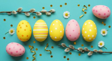 Paskalya arka planı. Sarı arka planda renkli paskalya yumurtaları. Paskalya konsepti. en üstteki görünüm.