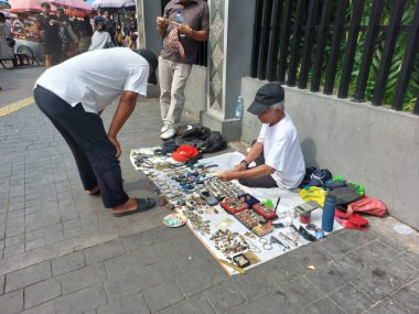 Yol kenarındaki alıcılar suç ortağı tüccarlarla görüşüyor.