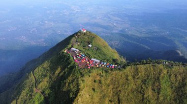 Bir kuş bakışı fotoğraflanmış bir çok dağcı çadırıyla dağ zirvesi