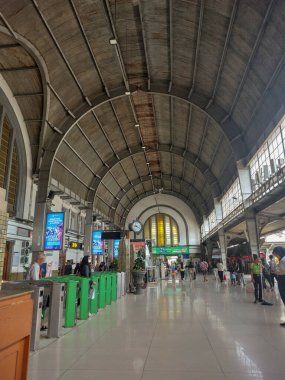 Tren istasyonunun içinde yüksek eğimli çatısı olan bir atmosfer.