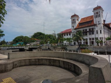 cast concrete seating for public facilities in the park with a white colonial building background clipart