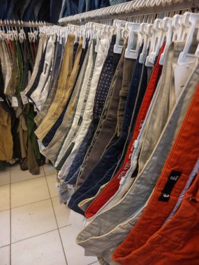 Bazı pantolonlar giyim mağazasında üst üste asılıdır.